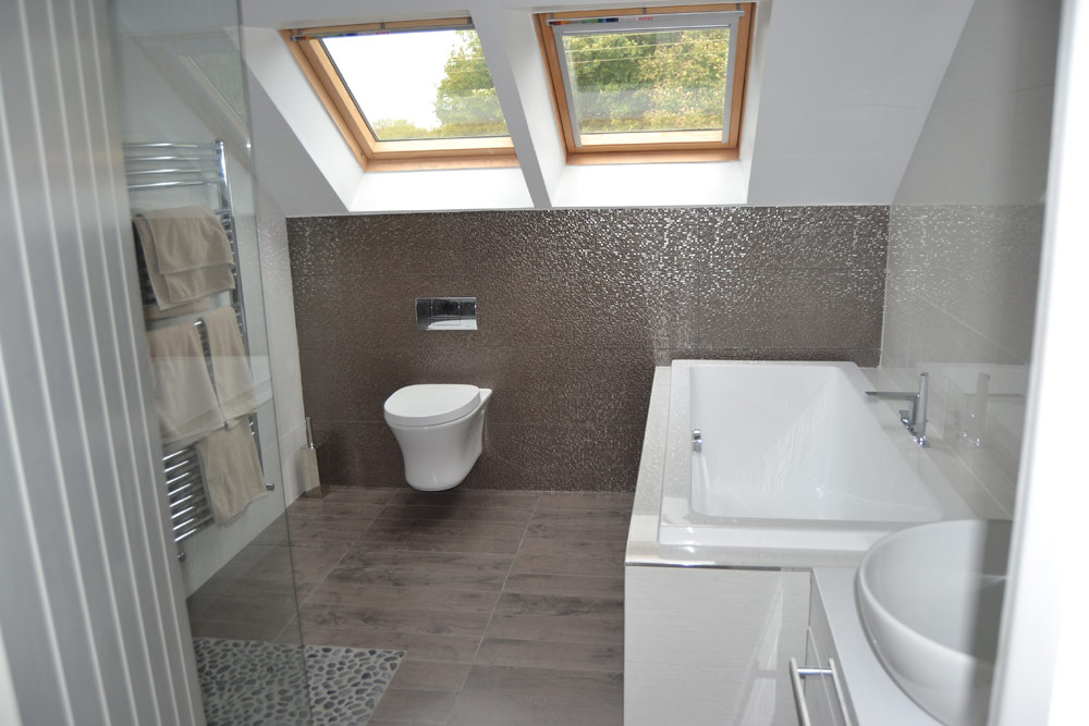 Modern bathroom with skylights, wall-mounted toilet, bathtub, and dark tile accents