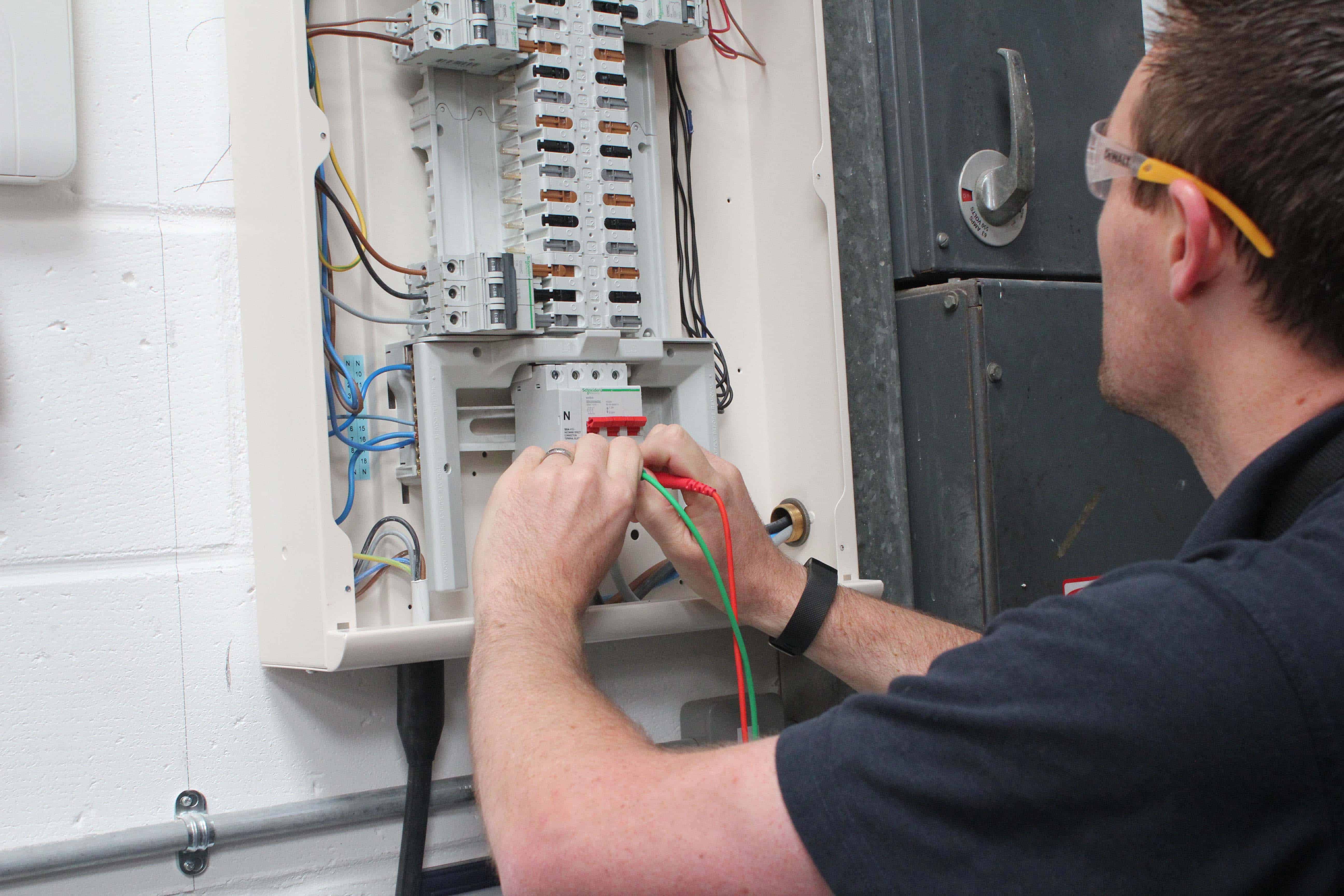 Electrician working on circuit breaker panel wiring installation